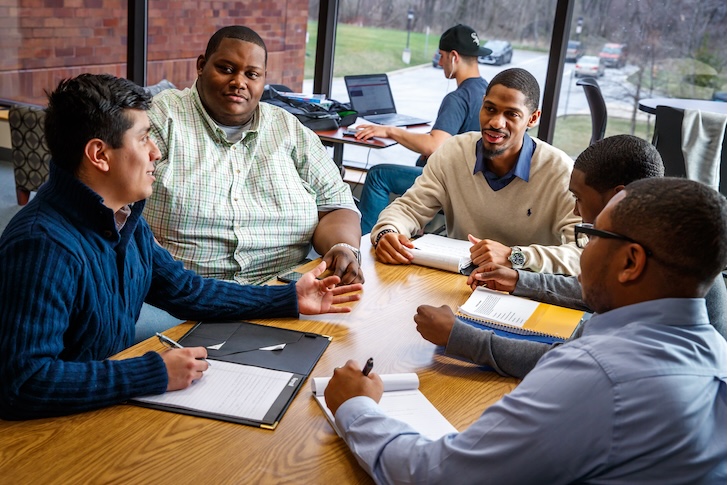 A group of people talking at a table A group of people talking at a table